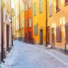 the narrow cobblestone street with a bicycles and yellow red medieval houses of gamla stan historic old center of stockholm at summer sunny day.