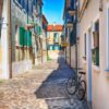 narrow street with a bicycle in the morning in murano island, venice, italy