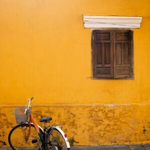 an old bicycle against a yellow wall in the old city of hoi an. place for the label .vietnam.