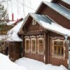 a russian wood house covered in snow