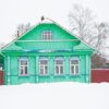 a russian wood house covered in snow