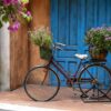 vintage bike with basket full of flowers next to an old building in danang, vietnam, close up