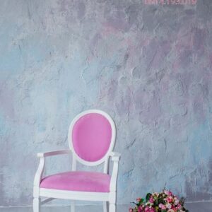 vintage chair against a gray wall with a vase with flowers on .c