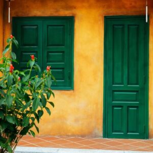 a yellow wall with a green door and a window with chinese lanterns.beautiful old architecture.vietnam.