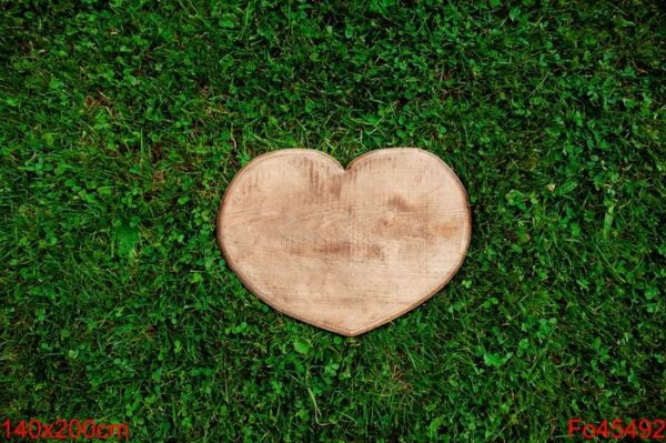 heart shape of wood, cut out in green grass