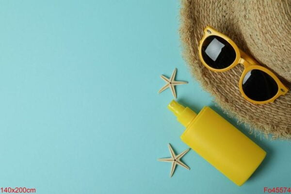 summer concept with sunscreen on blue background