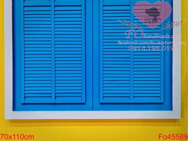 blue vintage wooden window with white frame on vivid yellow wall