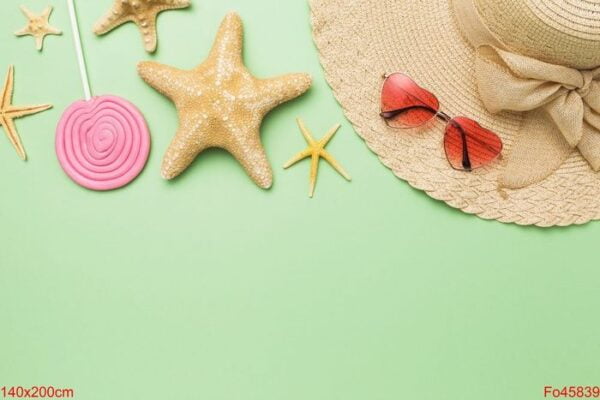 beach accessories, decorative starfish and lollipop on a green b