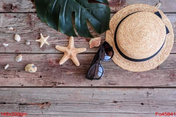 beach accessories: glasses and hat with shells and sea stars on a colored background