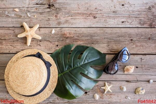 beach accessories: glasses and hat with shells and sea stars on a colored background