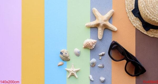 beach accessories: glasses and hat with shells and sea stars on a colored background