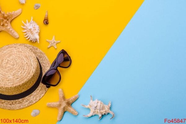 beach accessories: glasses and hat with shells and sea stars on a colored background