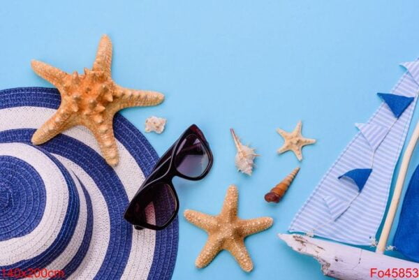 beach accessories: glasses and hat with shells and sea stars on a colored background