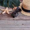 beach accessories: glasses and hat with shells and sea stars on a colored background