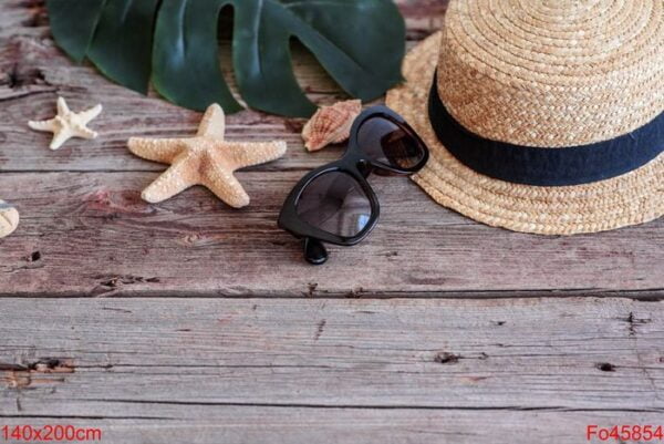 beach accessories: glasses and hat with shells and sea stars on a colored background