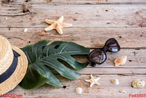 beach accessories: glasses and hat with shells and sea stars on a colored background