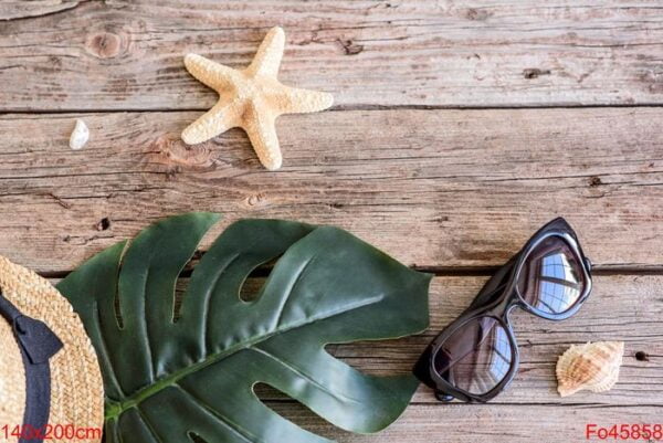 beach accessories: glasses and hat with shells and sea stars on a colored background