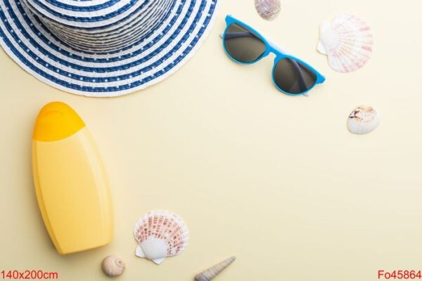 beach hat, sunglasses and sunscreen are among the seashells on a beige surface