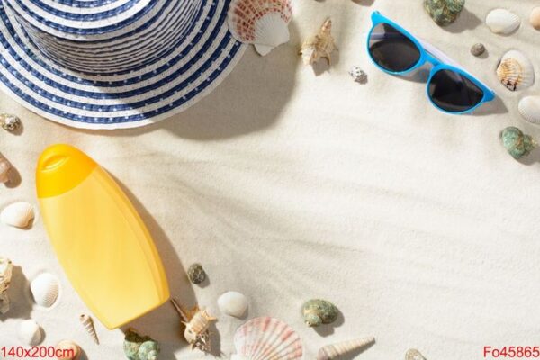 beach hat, sunglasses, and sunscreen are among the seashells on the sand