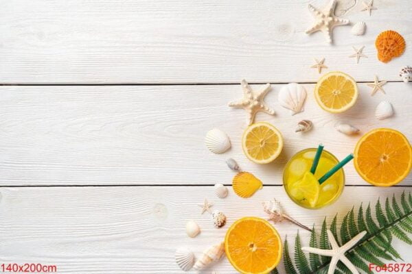 citrus fruits, iced cocktail, seashells and starfish on a white wooden background.