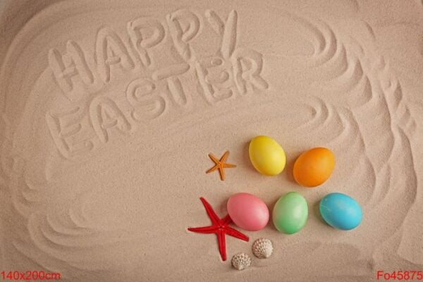 colorful eggs and text happy easter written on sand