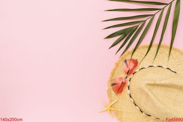 ladies straw hat, sunglasses and palm leaf on pink background wi