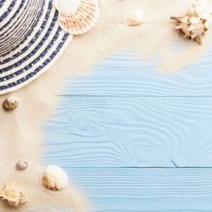 marine concept. beach accessories, sand and seashells on blue wooden table