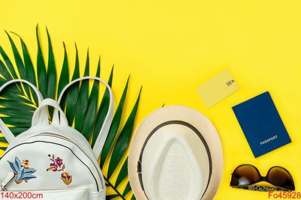 summer flat lay of female travel accessories on yellow background. top view, copy space.