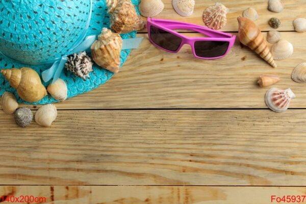 travel concept hat, glasses and shells on a natural wooden table. relaxation. holidays. top view. free space