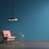 interior wall mockup in blue tones with red leather armchair on dark wall background.