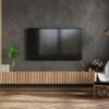 mockup a tv in modern living room with armchair and plant on concrete wall background.