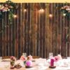 wedding venue. wooden wall at the banquet table with lamps and flowers. copy space