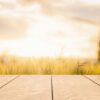 wooden table with blurred background of field of wheat. product display