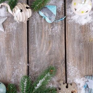 christmas composition with fir tree, toys and snow on wooden background