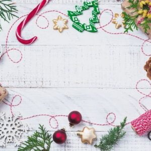 christmas background with fir branches, toys, gift box and bells on wooden old background table. selective focus. top view with copy space