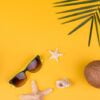 beach accessories with shells and sea stars on a colored background