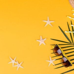 beach accessories with shells and sea stars on a colored background