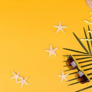 beach accessories with shells and sea stars on a colored background