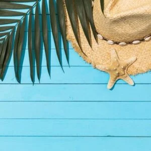 chico leaf, hat and starfish on a light blue wooden background w