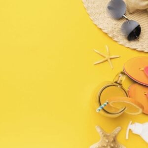 hat, sunglasses, beach slippers, starfish and orange juice on a