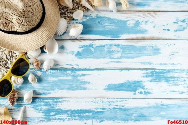 seashells on blue wooden board with straw hat and sunglasses.