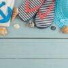 summer accessories. beach accessories. spanking, hat, shells and towel on a blue wooden table. top view. space for text