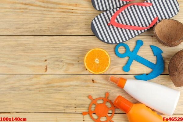 summer accessories. beach accessories. sunscreen, flip flops, and orange on a natural wooden table. top view. free place