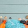 summer accessories. beach accessories. sunscreens, a hat, shells, and sunglasses on a blue wooden table. top view. place for text.