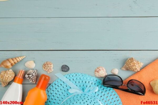 summer accessories. beach accessories. sunscreens, a hat, shells, and sunglasses on a blue wooden table. top view. place for text.