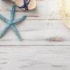 summer background concept: female sandals, starfish, straw hat on light wooden surface