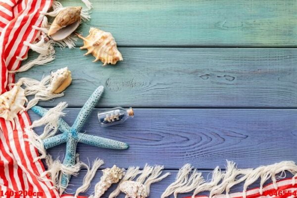 summer background: fringed pareo, seashells, boat in a bottle, starfish on a blue wooden background