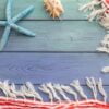 summer background: fringed pareos, seashells on a blue wooden background