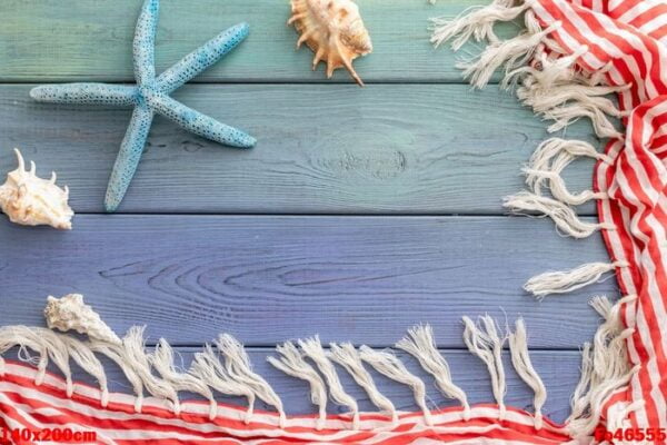 summer background: fringed pareos, seashells on a blue wooden background