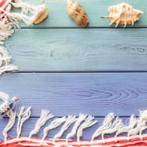 summer background: fringed pareos, seashells on a blue wooden background